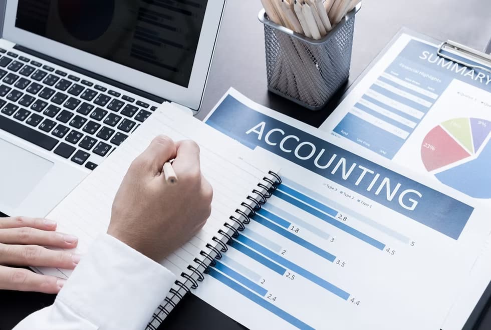 Laptop with accounting notebook
